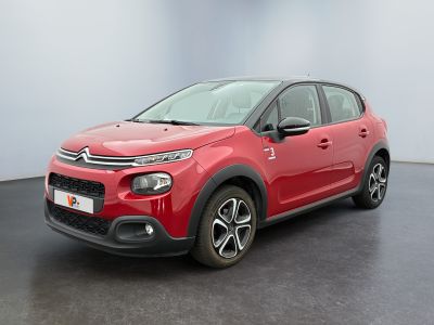 La Citroën rouge est garée dans une pièce au sol noir.