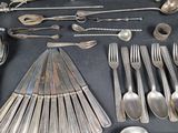 a lot of silverware on a table with spoons and spoons