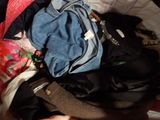 a pile of clothes sitting on top of a bed