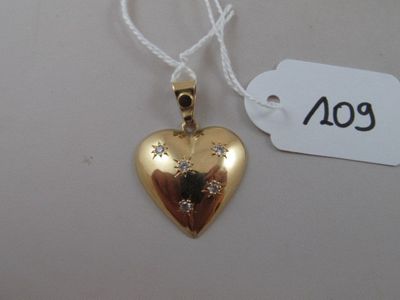 a gold heart shaped pendant with a diamond on it