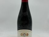 une bouteille de vin posée sur une table blanche