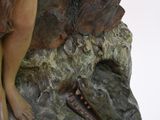 statue of a woman sitting on a rock with a chain around her neck