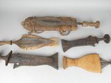 several pieces of carved wood are displayed on a white surface
