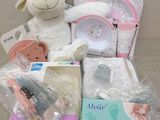 un mouton en peluche posé à côté d'une boîte contenant des articles pour bébé
