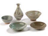 five bowls and a vase on a white surface