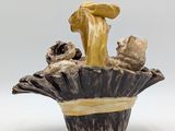 a small vase with mushrooms in it on a white surface