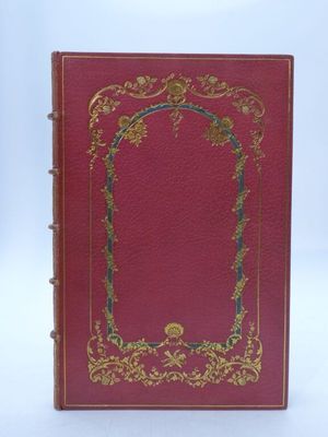 un vieux livre rouge aux tranches dorées et orné d'un cadre décoratif