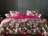 un lit recouvert d'une couette rose et d'oreillers roses