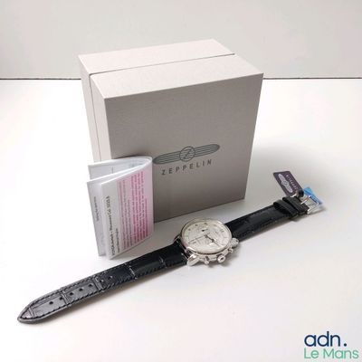 une montre posée sur une table à côté d'une boîte