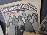 newspapers with a picture of a man standing in front of a group of people
