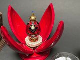 a red flower shaped object with a candle on top of it