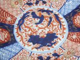 a blue and orange plate with birds and flowers on it