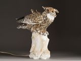 a statue of an owl sitting on top of a tree stump
