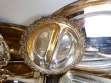 de nombreux plateaux et plats en argent sur la table