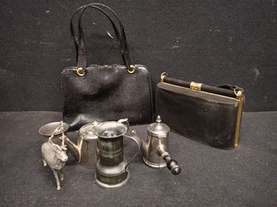 un sac à main noir, une théière en argent et une théière en argent