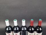 six bottles of wine are lined up in a row on a table