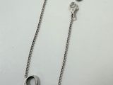 a close up of a silver necklace on a white surface