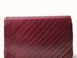 the red purse is sitting on a white surface