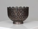 a silver bowl sitting on top of a white table