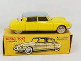 yellow toy car sitting on top of a yellow box on a white surface