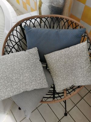 four pillows on a chair in a room