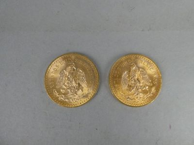two pieces of gold coins sitting on top of a white surface