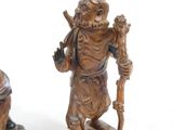 two figurines of a man holding a stick and a pot
