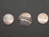 four quarters of different types of coins on a black surface