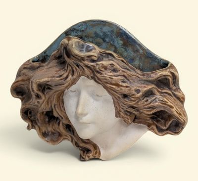 une sculpture représentant la tête d'une femme aux cheveux longs