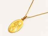 un gros plan sur un collier en or orné d'une image représentant une femme