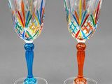 two wine glasses that are sitting next to each other