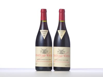 two bottles of red wine sitting on top of a white table
