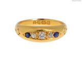 un gros plan d'une bague en or jaune sertie de saphirs et de diamants