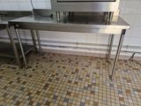 une table en acier inoxydable sur laquelle est posé un micro-ondes