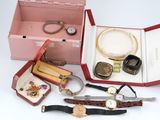 many different types of watches and jewelry in a pink box