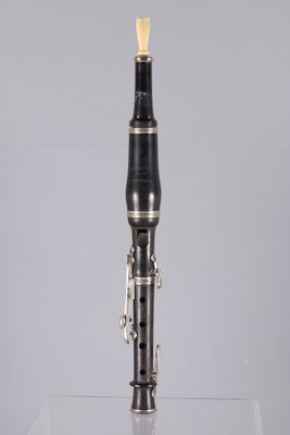 a close up of a black and gold clarinet on a clear surface