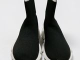 black and white sneakers with white soles on a white surface