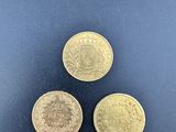 three british coins are shown on a black surface