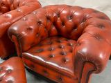 a red leather chair and ottoman sitting on the floor