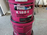 Plusieurs seaux de peinture rose sont empilés les uns sur les autres