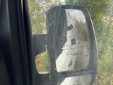 a side view mirror of a car that is parked on the side of the road