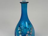a blue glass bottle with a glass stopper on it