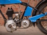 a blue motorcycle that is parked in front of a brick wall