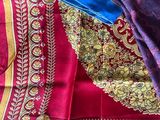 purple and red sari with a blue blouse on top of it