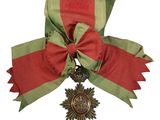 une image représentant un ruban rouge et vert sur lequel est accrochée une médaille en or