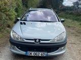 a silver car parked on a dirt road next to trees