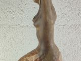 a statue of a woman holding a bowl on top of a book