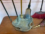 several brooms and brushes are sitting on a table near a brick wall