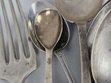 a lot of silver spoons and spoons on the table