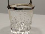 crystal ice bucket with metal handle on white surface
